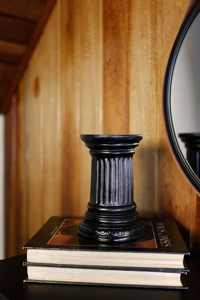 Candle holder styled beside a round mirror