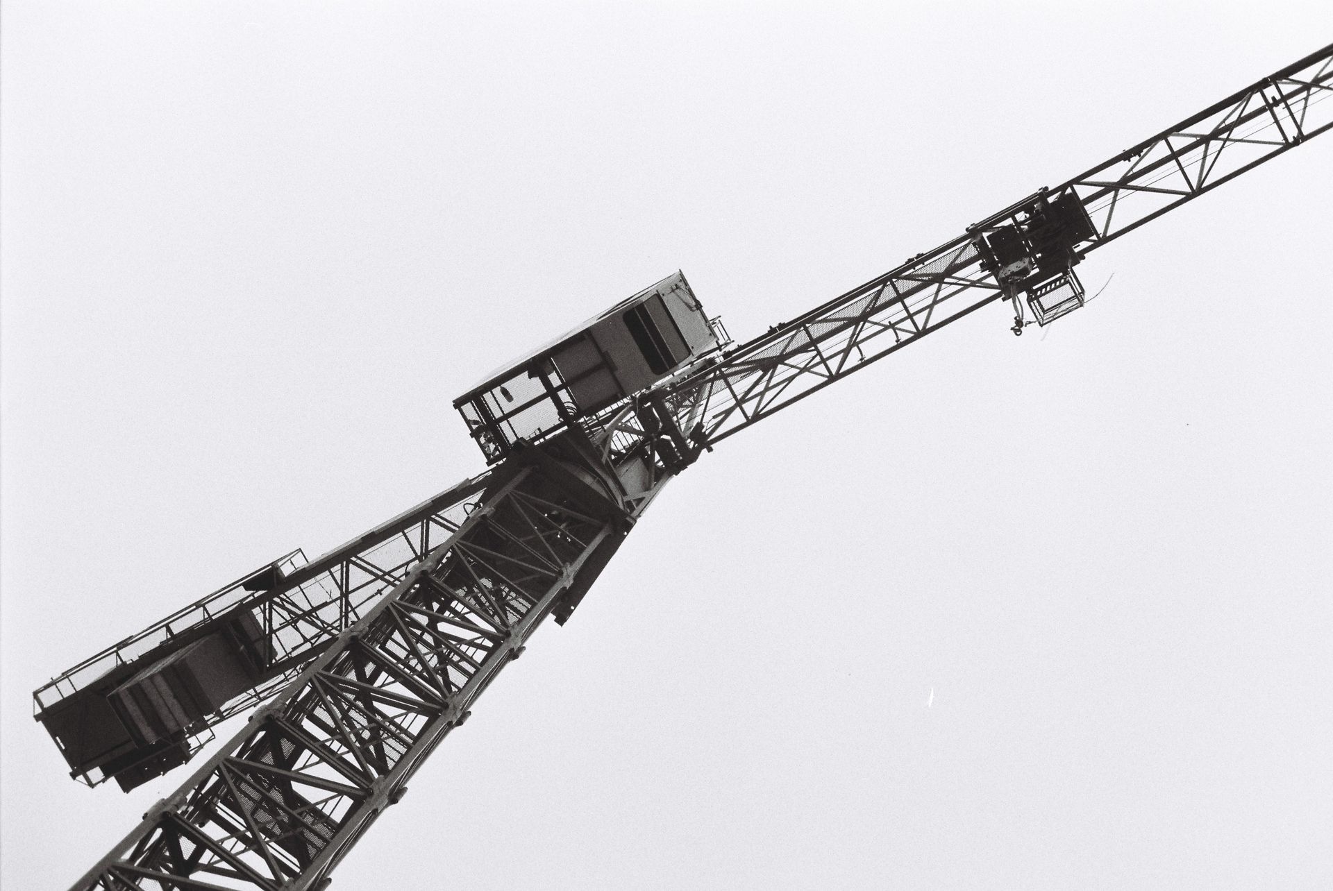 Artistic black and white photo of a construction crane from below.