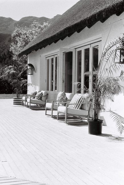 Beautiful modern patio with comfortable seating, a mountain view, and tropical plants.