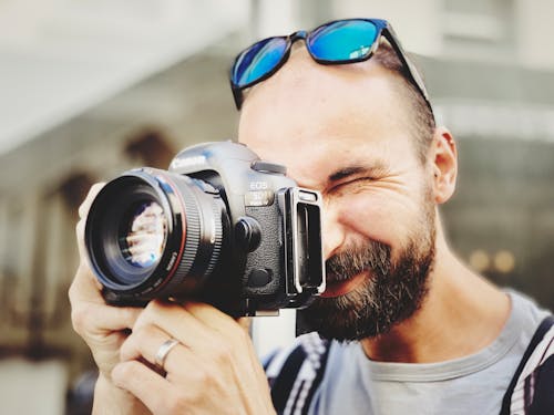 Man Wearing Gray Crew Neck Shirt Taking Photo Using Black Canon Camera