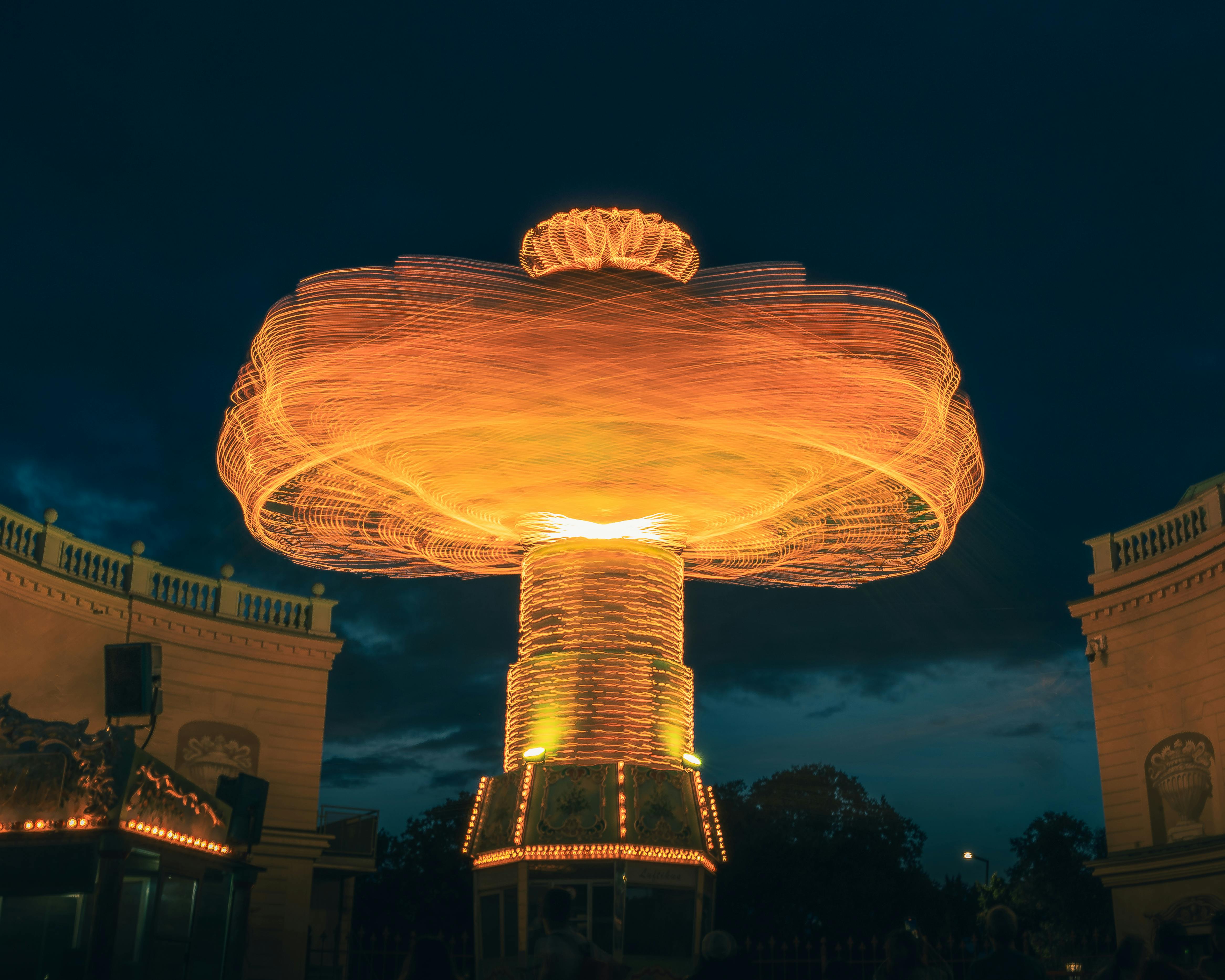 Long exposure of a spinning swing ride illuminates the night at an amusement park in Vienna, Austria.