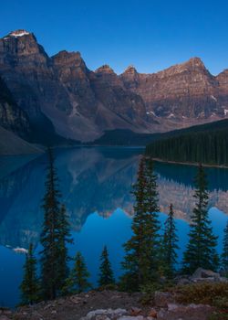Breathtaking view of Moraine Lake and the Canadian Rockies at sunrise, showcasing pristine nature.