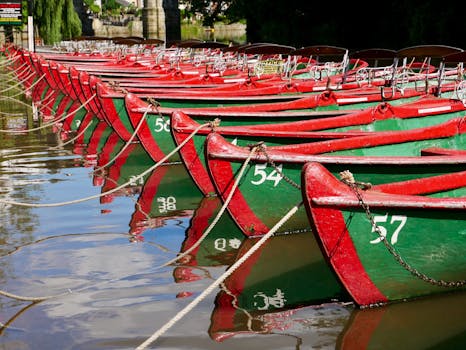 Vibrant red and green boats moored on the River Nidd, ideal for hire and leisurely river cruises.