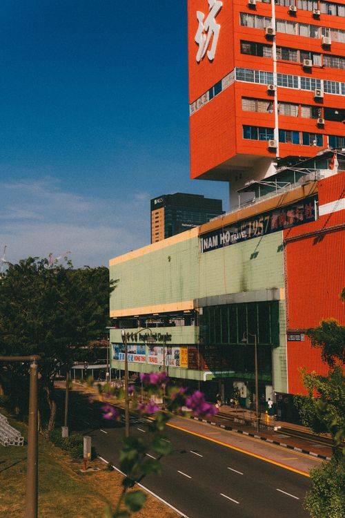 Free Colorful urban architecture with red and green buildings, trees lining the street. Stock Photo