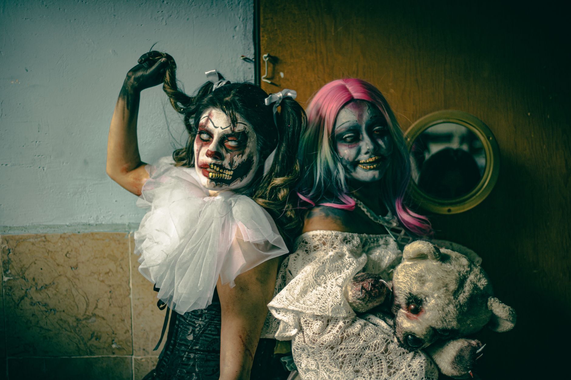 A unique photo depicting two adults with artistic zombie makeup in a spooky setting.
