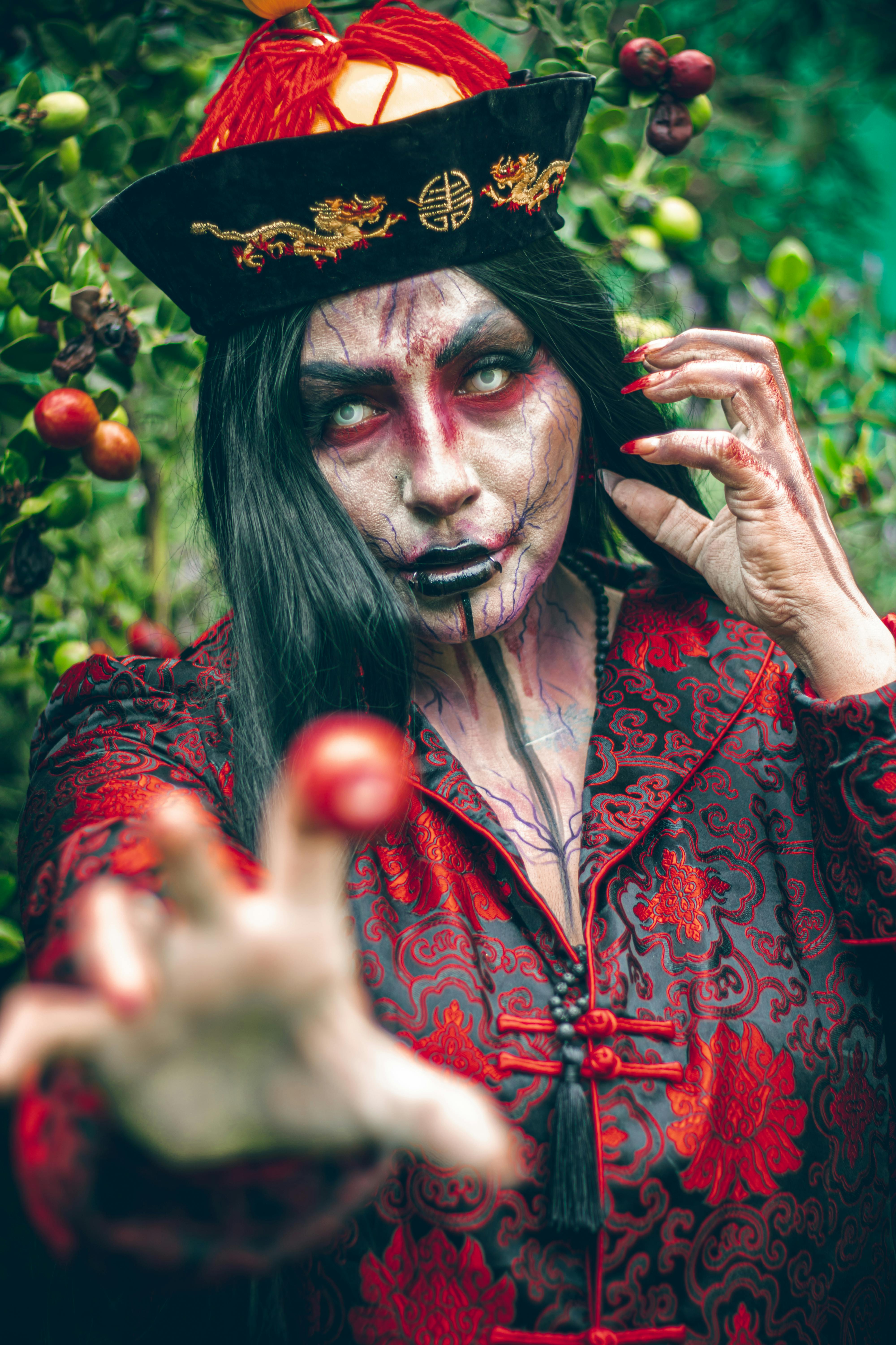 Ücretsiz Açık havada, karmaşık iblis temalı makyaj ve geleneksel Çin kıyafetleri giymiş bir modeli sergileyen dramatik bir portre. Stok Fotoğraflar