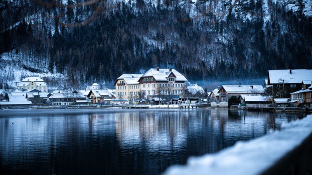 Experience the serene winter beauty of Hallstatt, Austria with snow-covered village by the lake.
