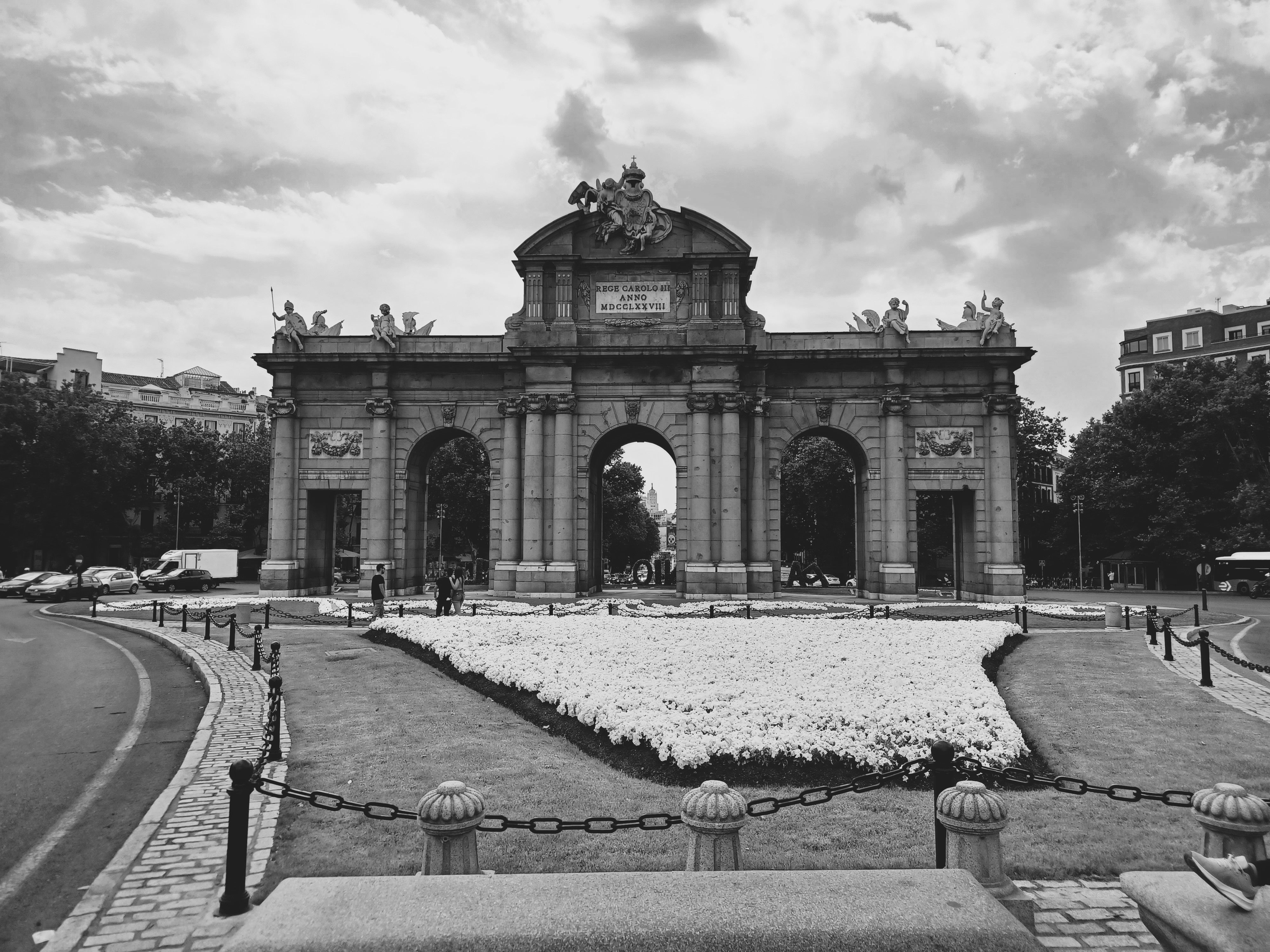 Monochrome image of the iconic Puerta de Alcalá archway in Madrid, Spain.