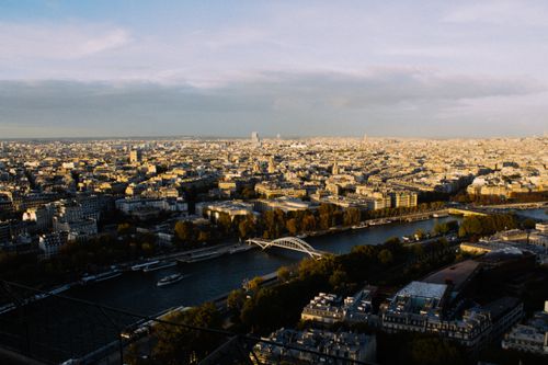 Free A breathtaking aerial view of Paris with the Seine River and iconic cityscape at sunset. Stock Photo