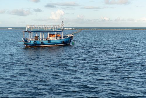 Free A serene scene of a blue boat floating in the clear waters of Arraial d'Ajuda, Bahia, Brazil. Stock Photo