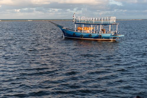 Free A picturesque blue boat floating in calm ocean waters under a cloudy sky in Arraial d'Ajuda, Bahia, Brazil. Stock Photo