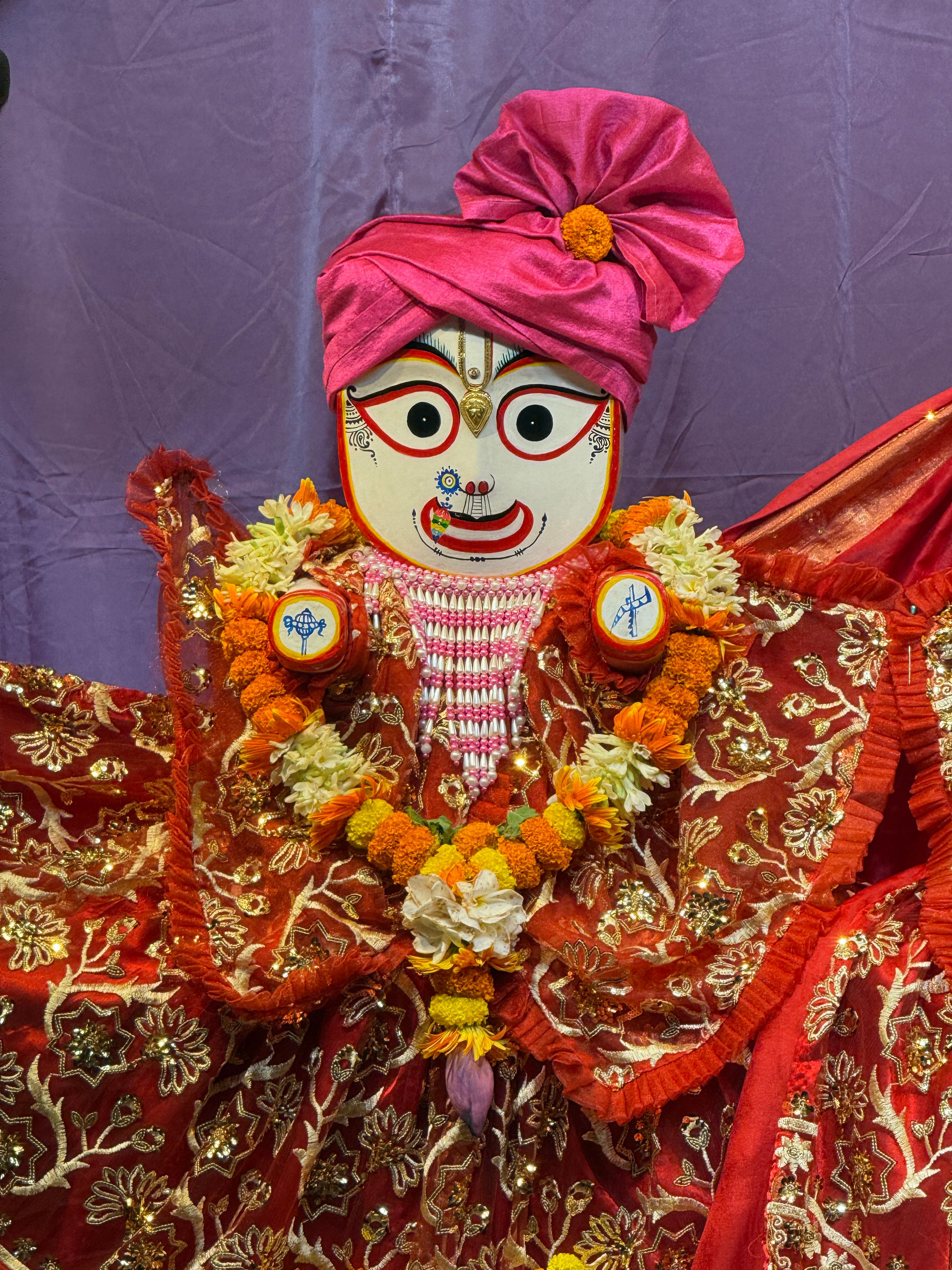 Colorful Indian puppet adorned with intricate fabrics and garlands, showcasing cultural artistry.