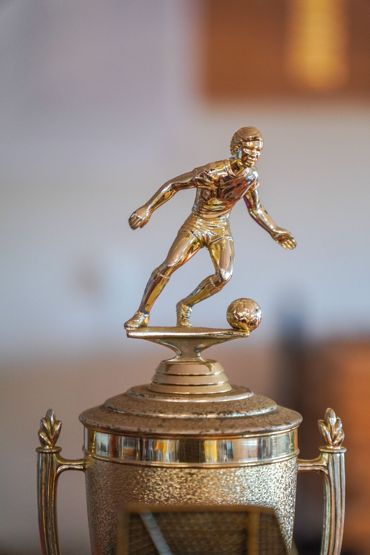 A close-up of a golden soccer trophy