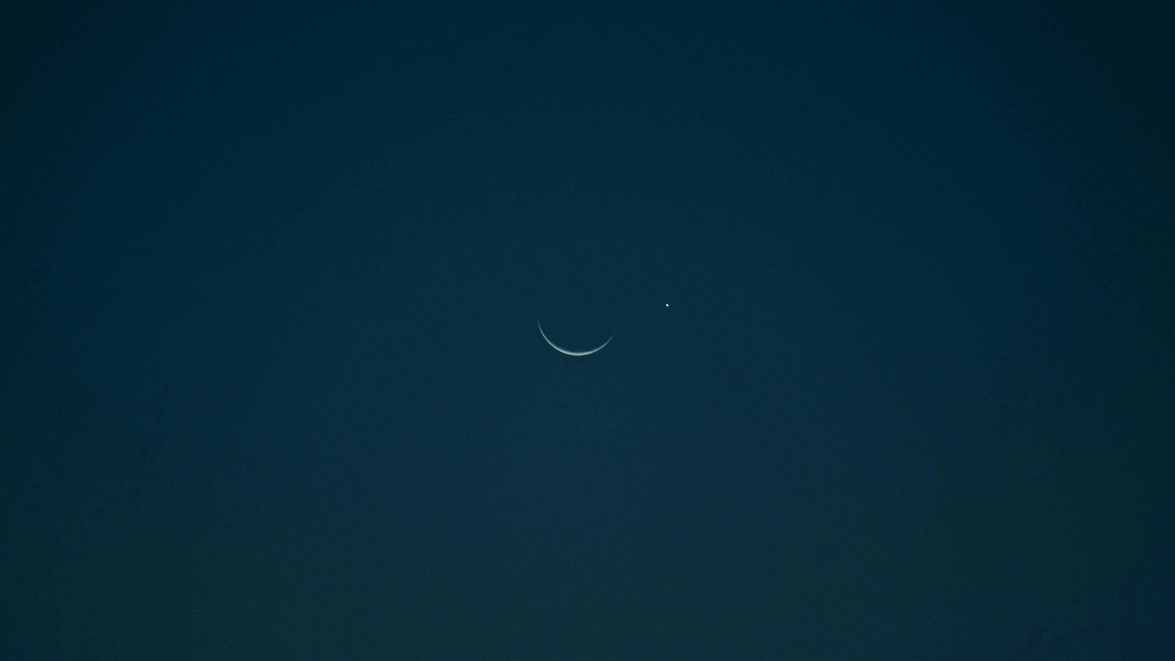 Kostenlos Eine ruhige Mondsichel und ein heller Planet vor einem dunklen Nachthimmel. Stock-Foto