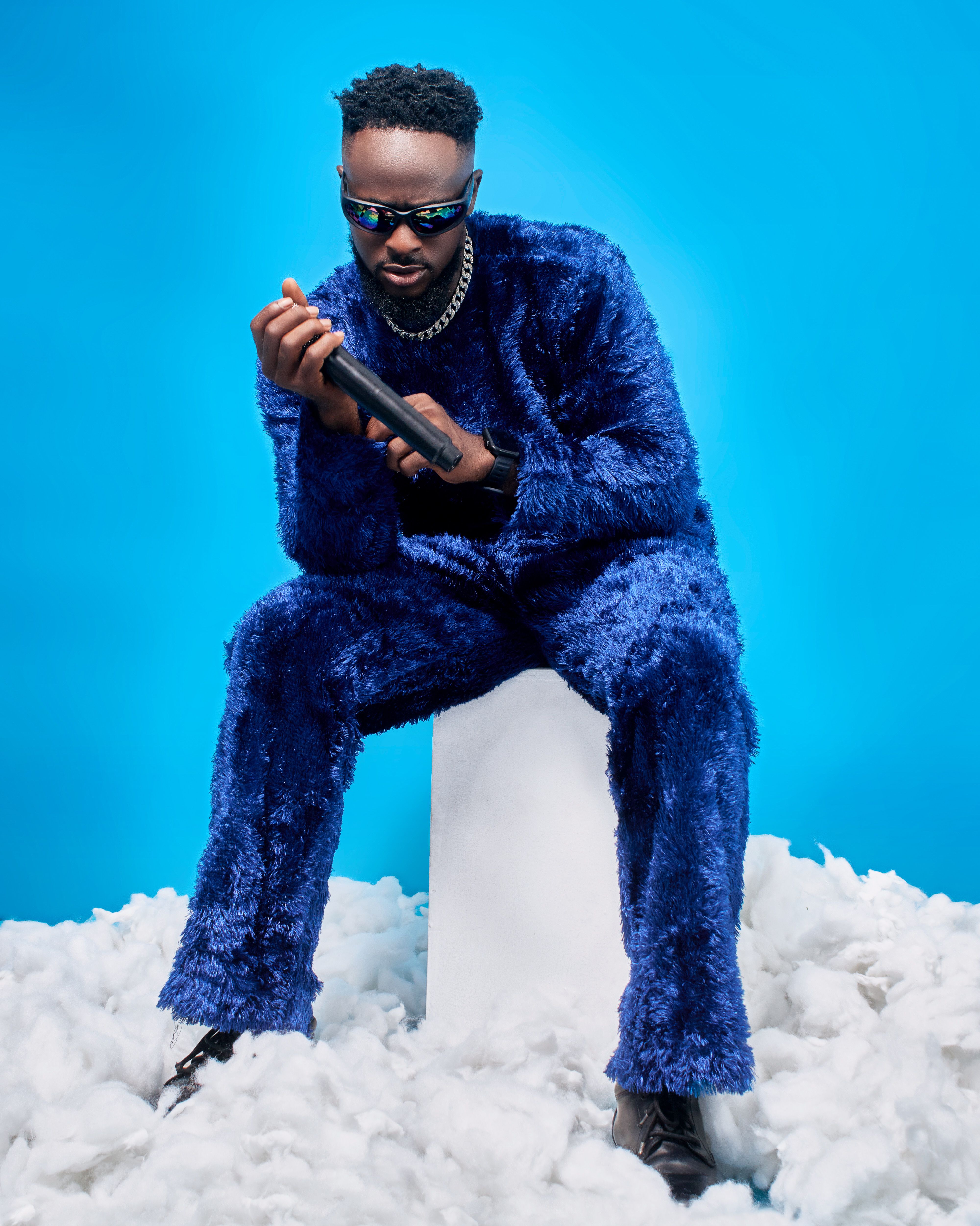 Fashionable Man in Fuzzy Blue Outfit on Cloudy Set · Free Stock Photo