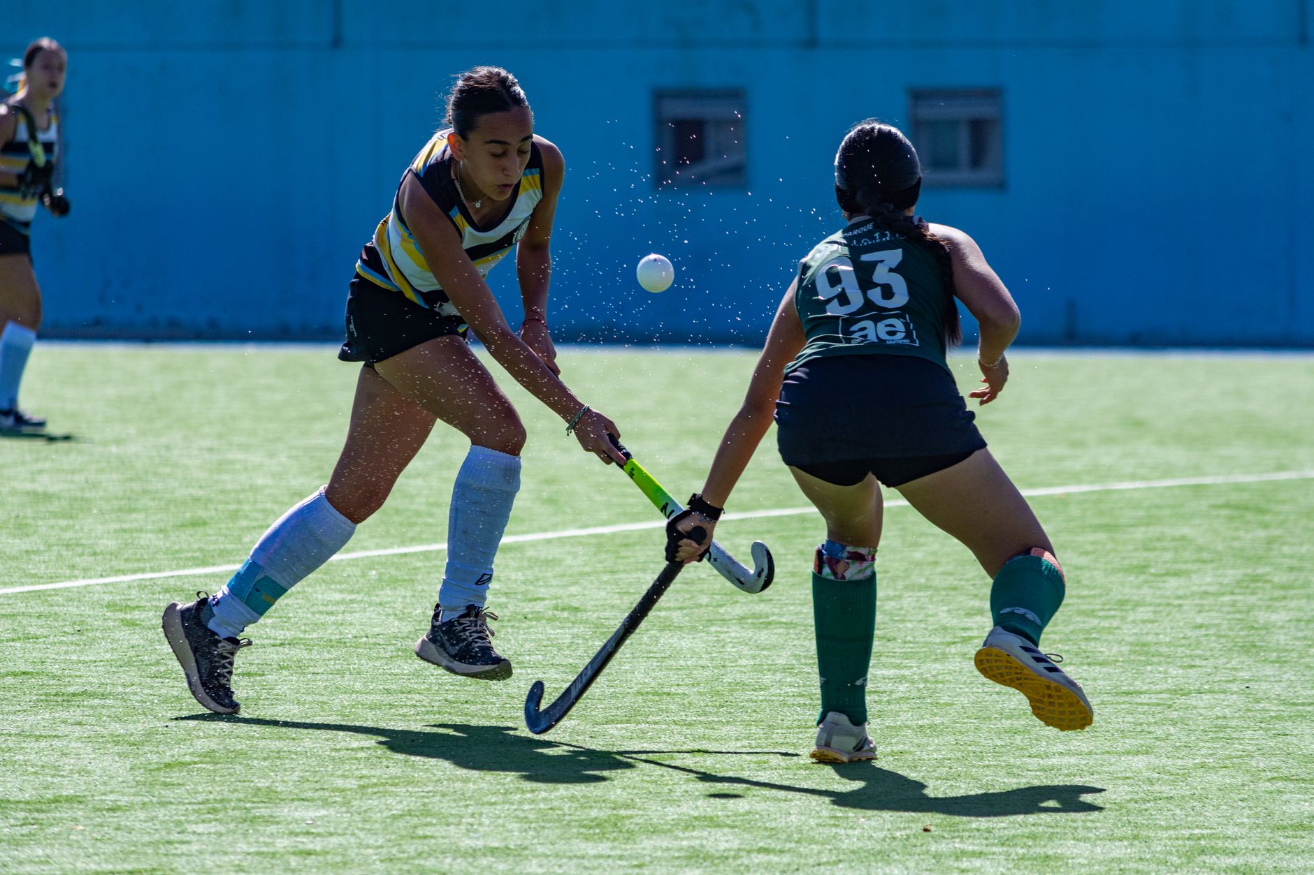 Dynamic moment from a field hockey game highlighting athletic skill and competition.