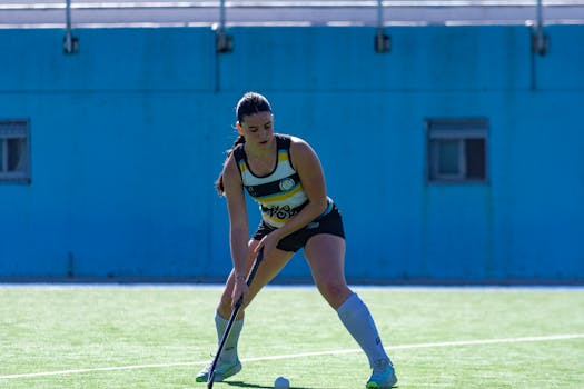 Action shot of a female field hockey player concentrating on the game outdoors.