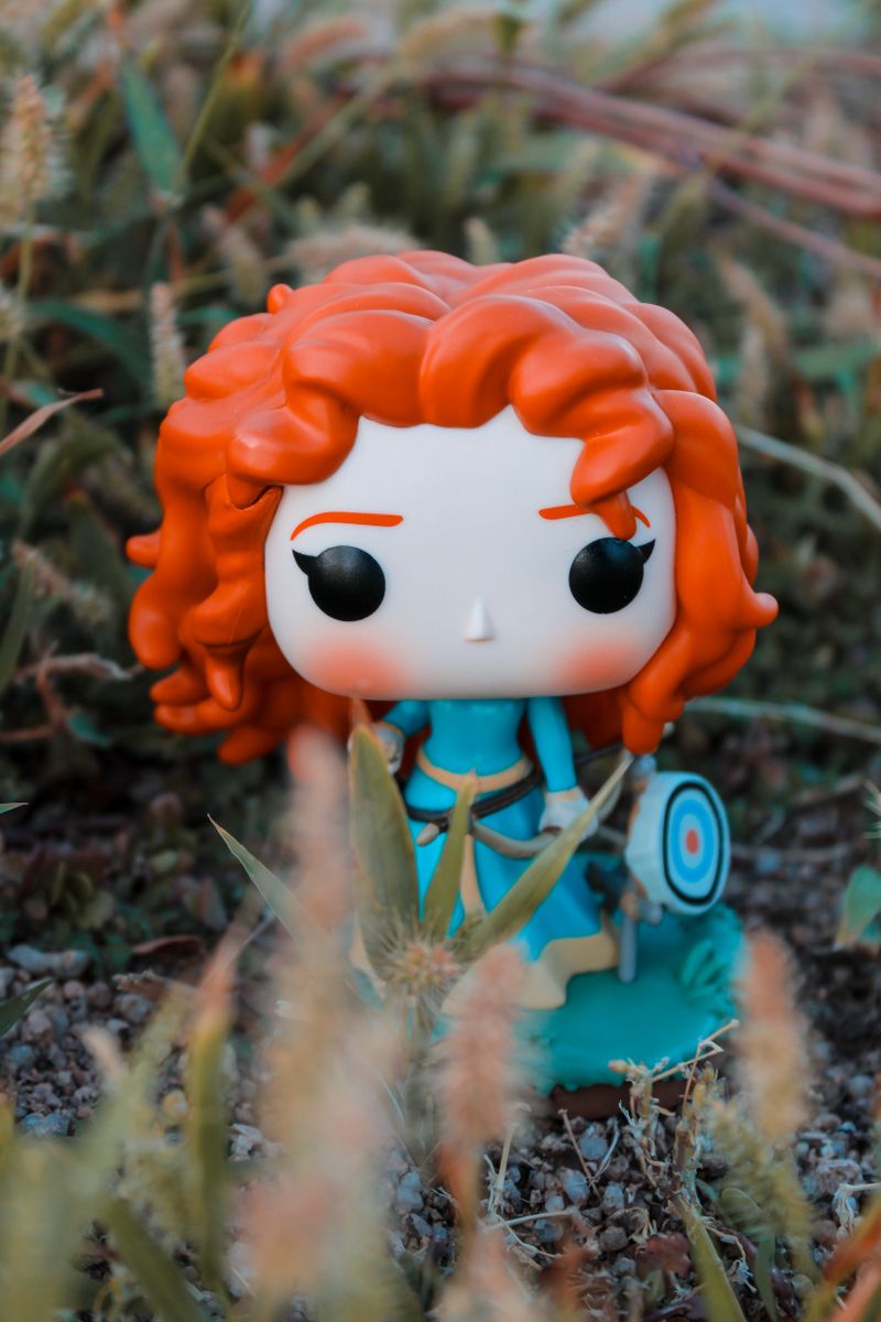 Colorful vinyl figure in nature setting demonstrating AI-assisted art toy design process and sculpting workflow