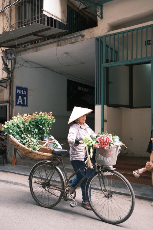 Free A street vendor with a bicycle full of flowers, showcasing urban street commerce. Stock Photo