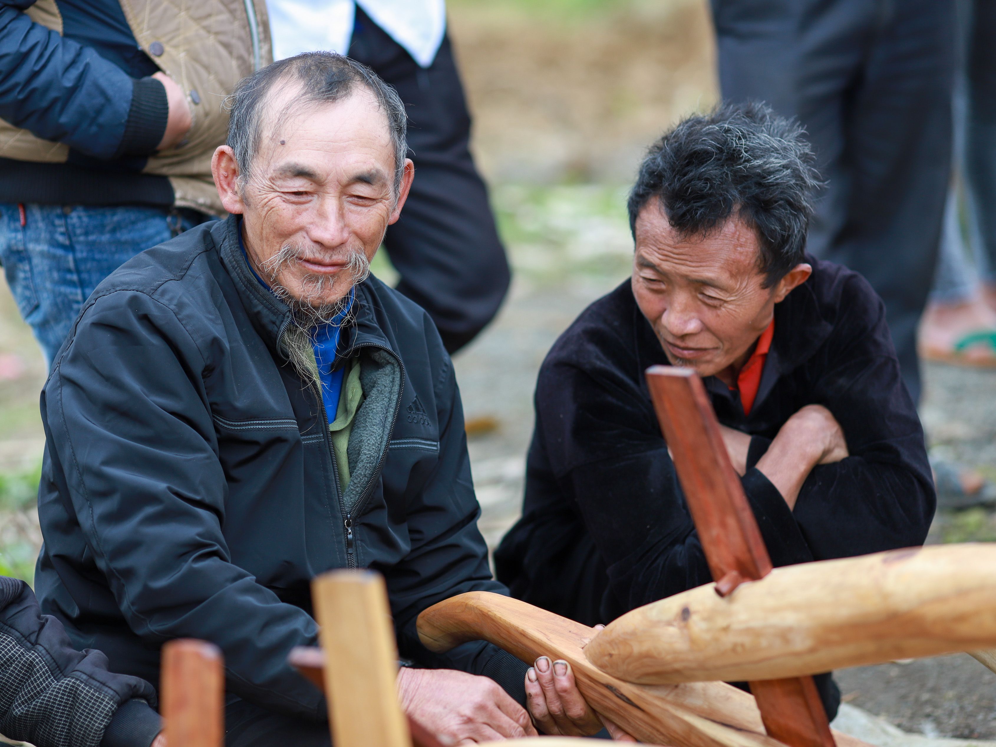 Hmong artisans sharing a moment of craftsmanship in Lào Cai, Vietnam.