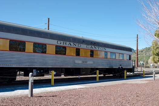 A Grand Canyon train at the station in Williams, Arizona under a clear sky.