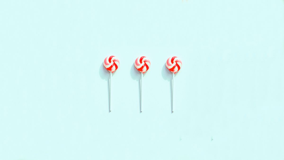 Three red and white lollipops on a light blue background, minimal and colorful design.