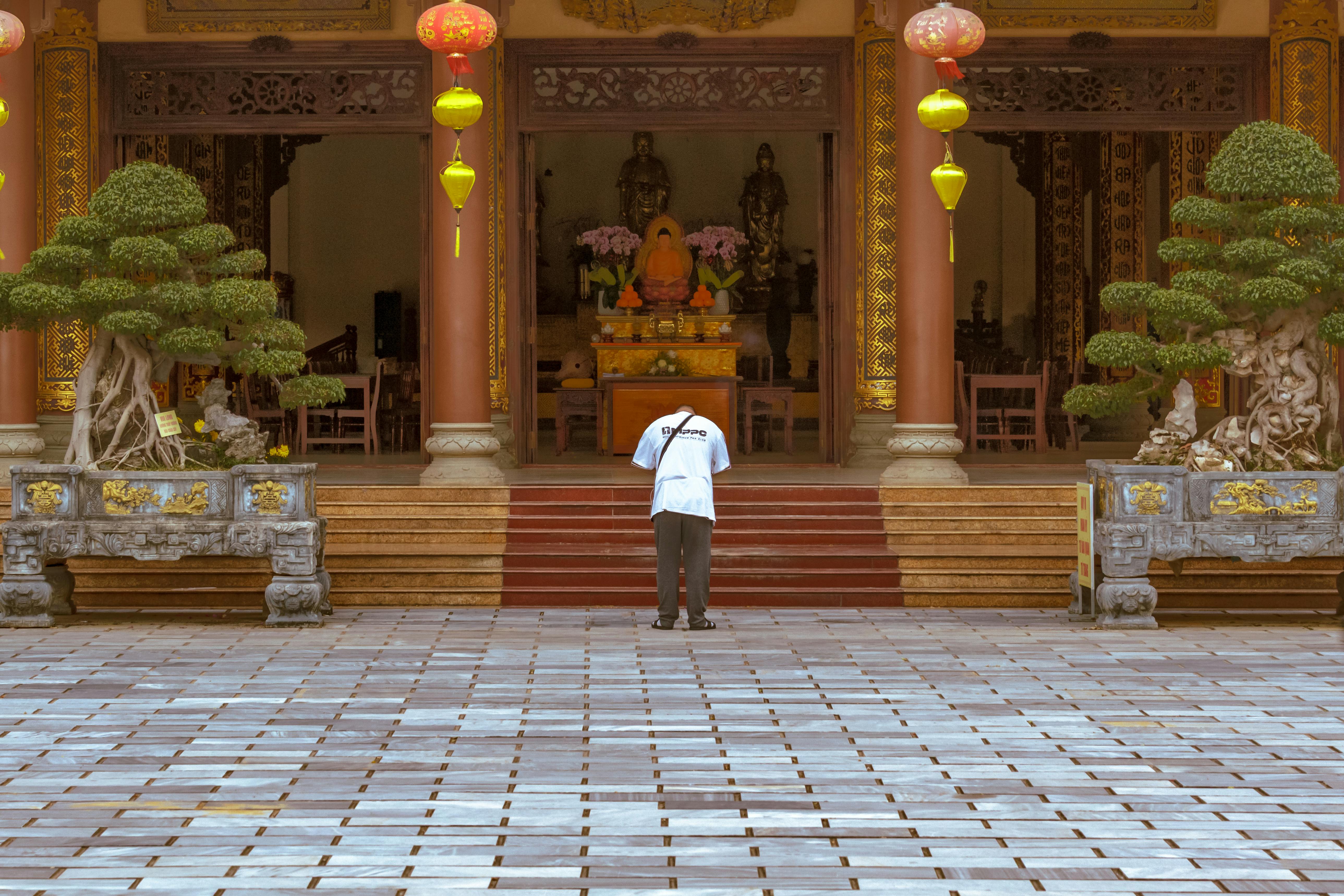 Man Wearing a White T-shirt Praying to Buddha in Pagoda located in Lien Chieu, Da Nang, Vietnam