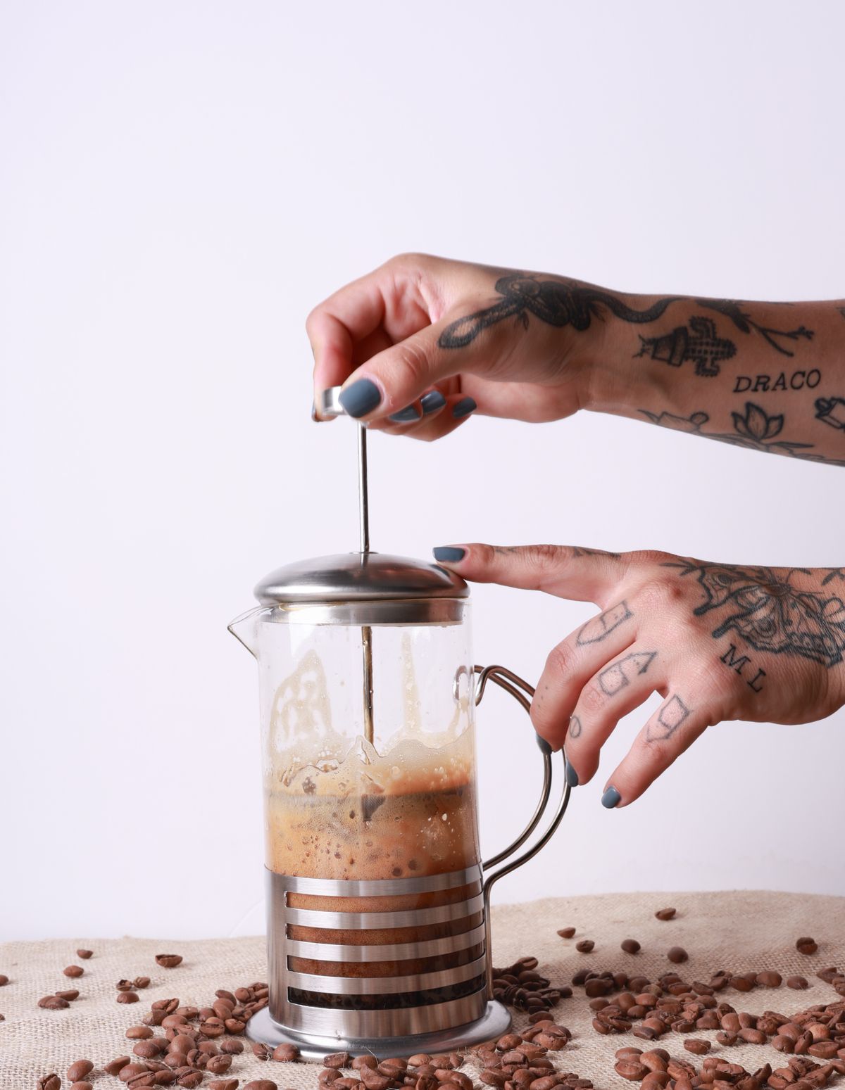 Maini apasand pistonul unui French Press pentru a separa zatul de cafea