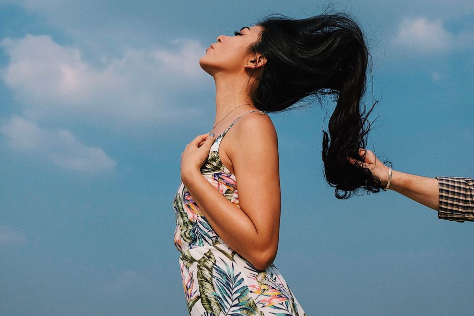 person with healthy, flowing hair in a natural outdoor setting - collagen peptides help hair growth