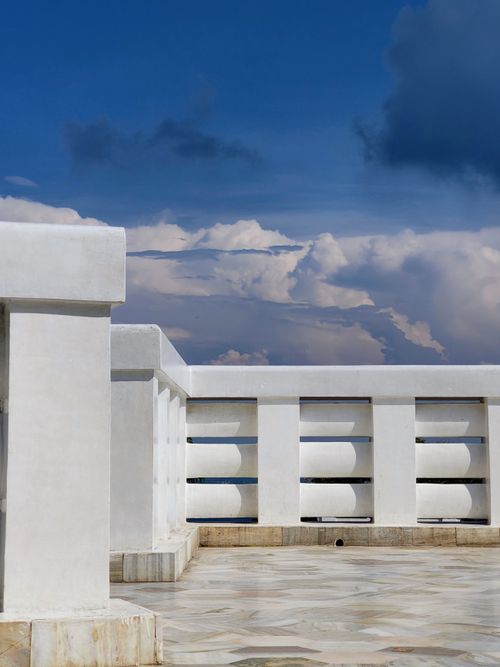 Free Sleek white rooftop with geometric design under a vibrant blue sky. Stock Photo