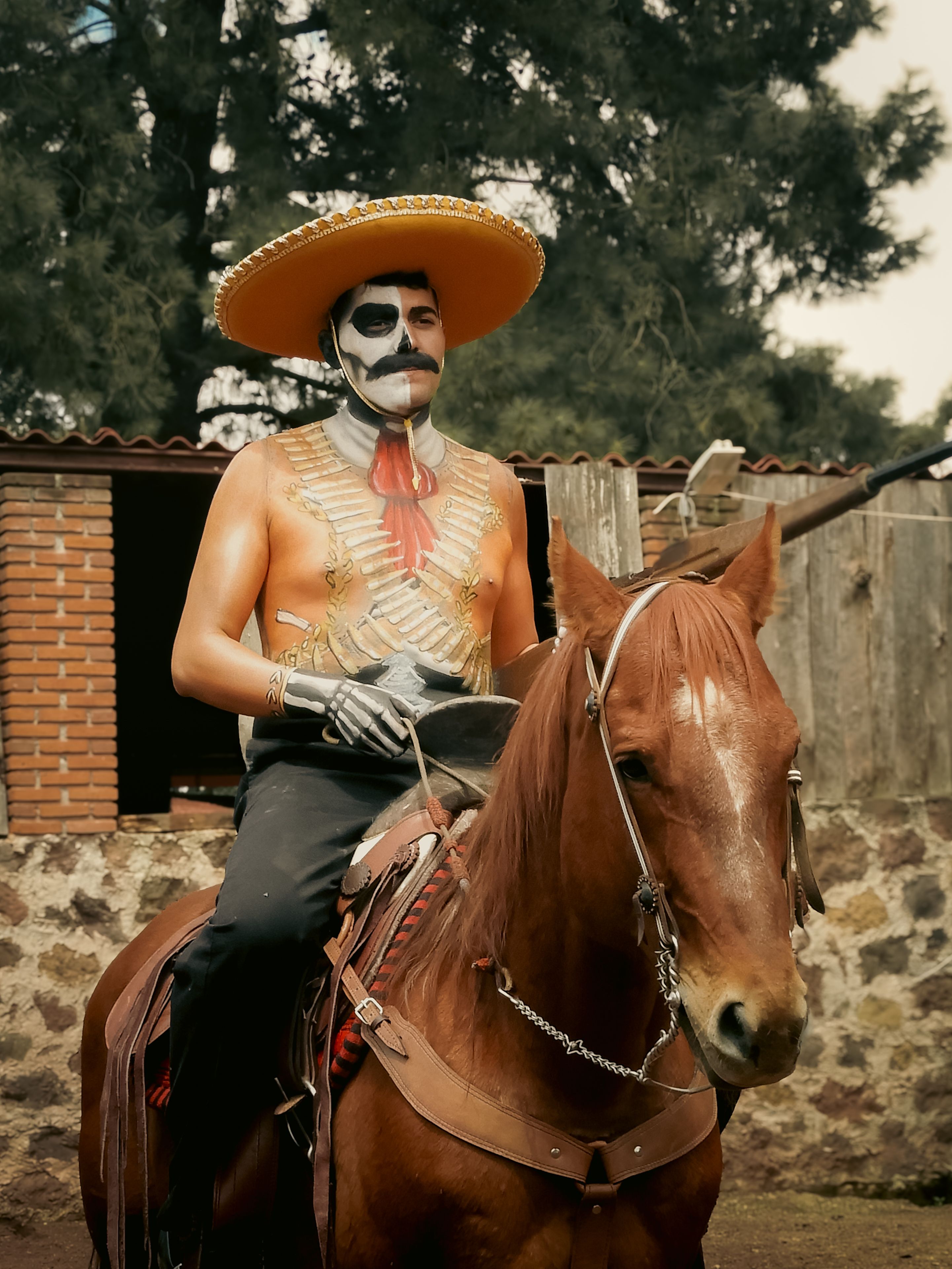 A man dressed in Day of the Dead attire and makeup rides a horse in Ciudad de México.