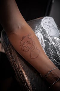 Minimalist line art tattoo on arm
