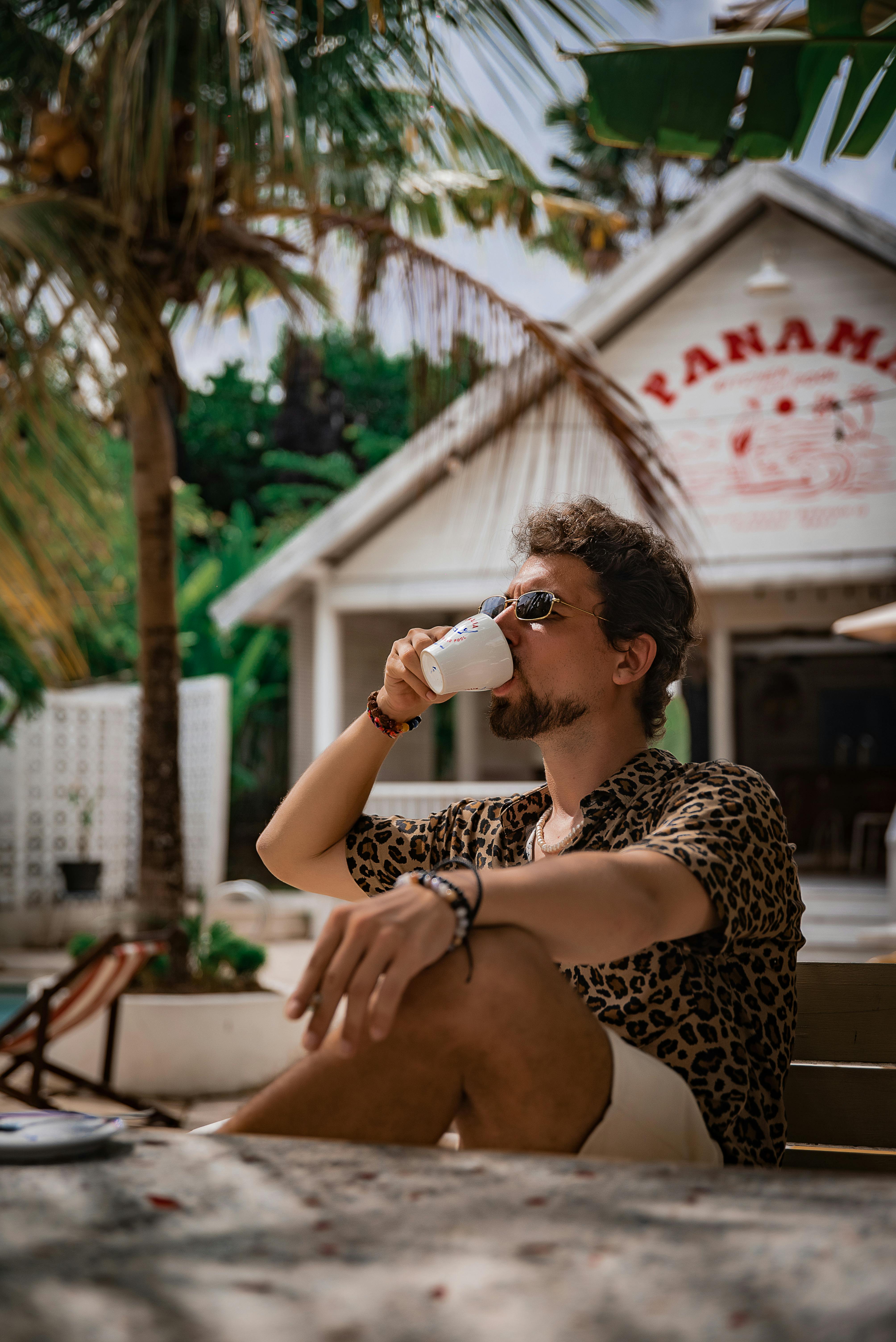 Free Casual man enjoying coffee outdoors in sunny Bali, Indonesia. Stock Photo