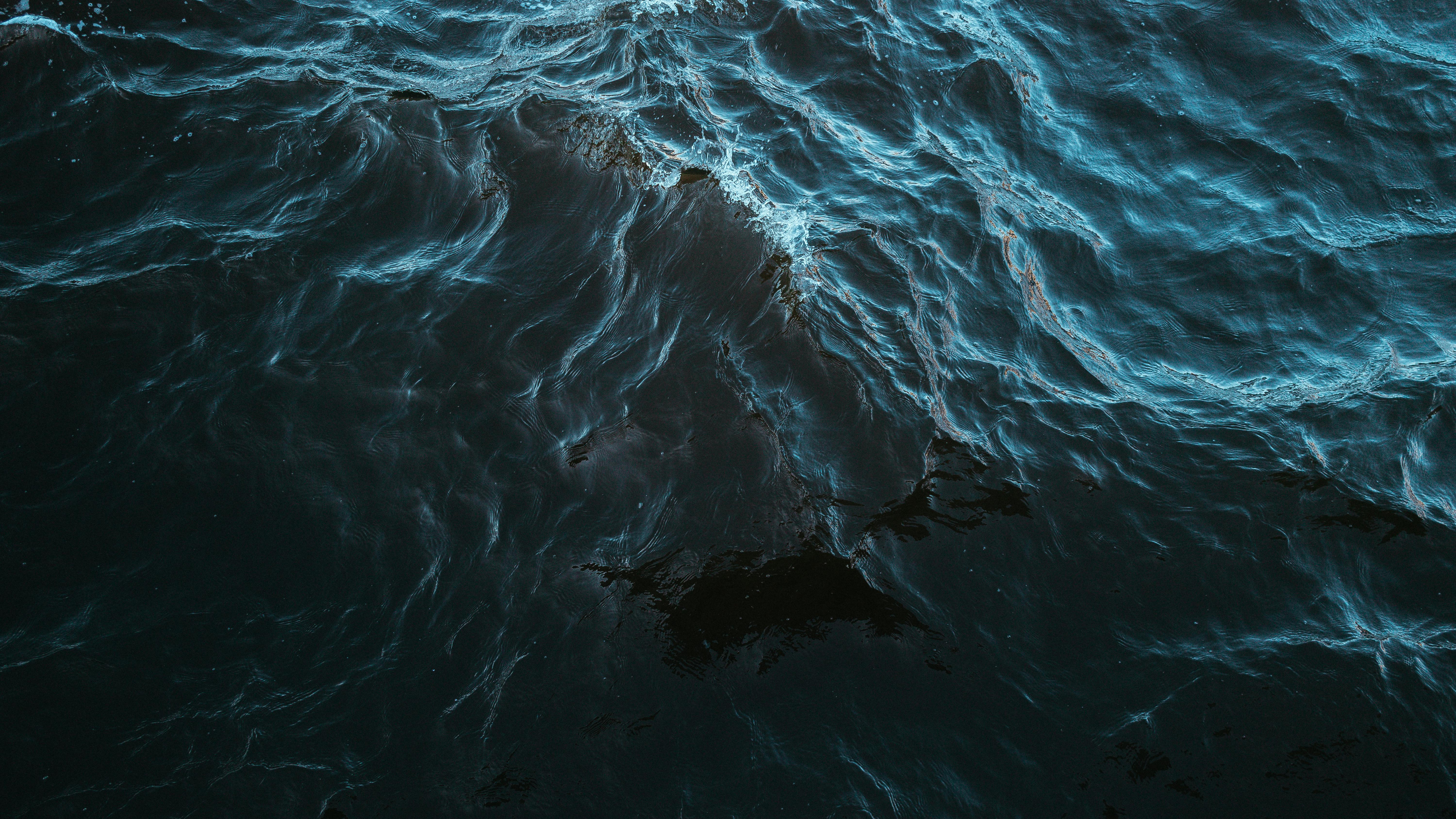 Dynamic image capturing dark blue ocean waves with vivid highlights.