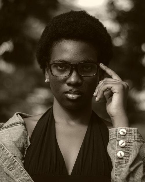 Free Elegant sepia-toned portrait of a woman with glasses and natural hairstyle. Stock Photo