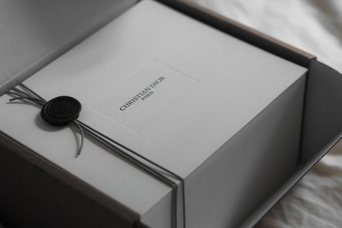 Free Stylish unboxing of Christian Dior package with classic branding in Paris setting Stock Photo