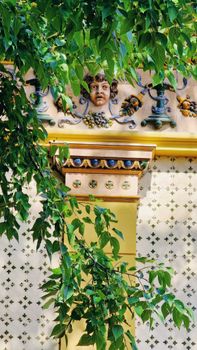 Intricate architectural detail with colorful facade and foliage in Pecs, Hungary.