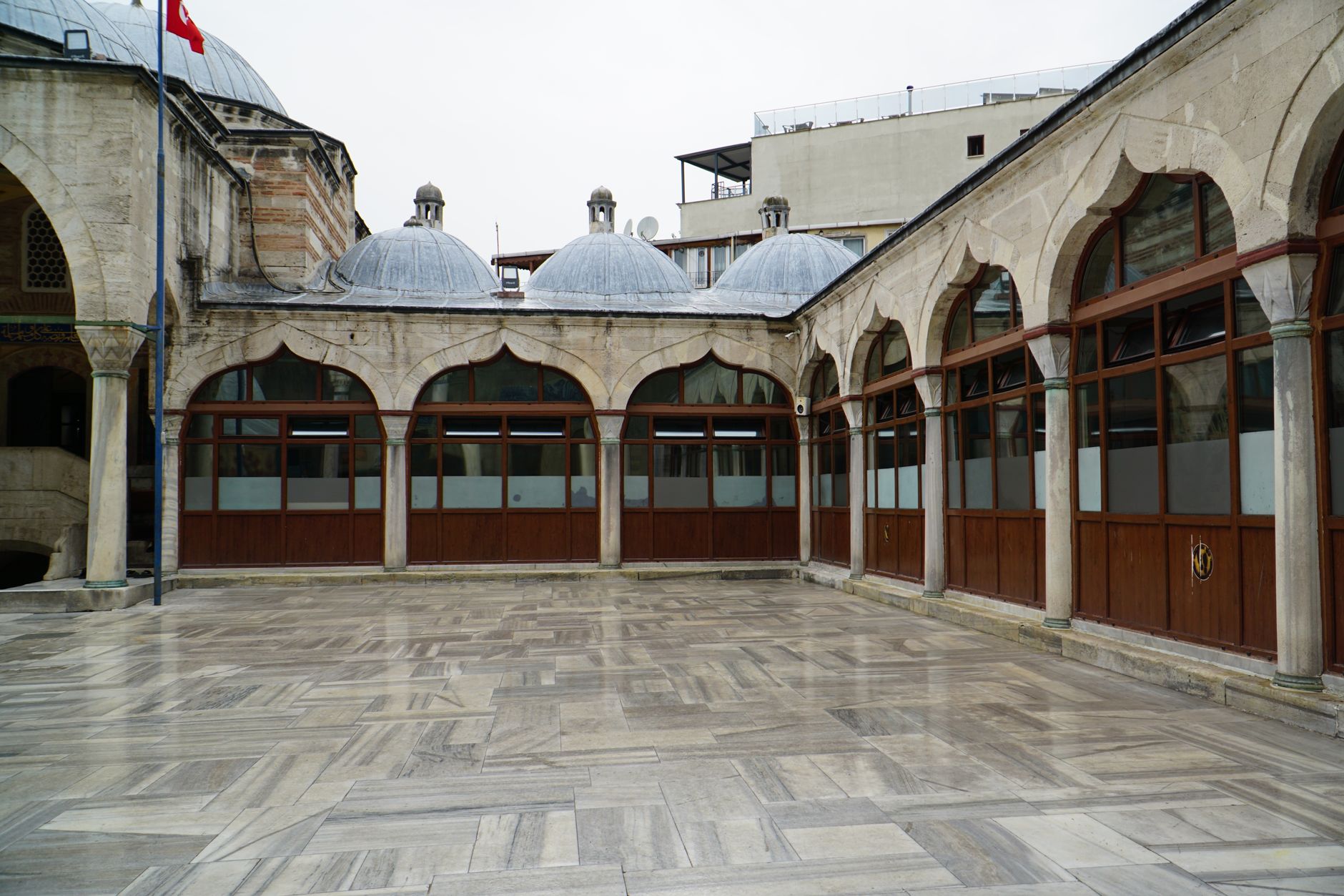 A serene courtyard with arched designs and domed rooftops, reflecting historical architecture.