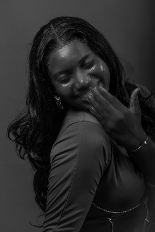 Free A joyful black and white portrait of a woman smiling gracefully with a charming expression. Stock Photo