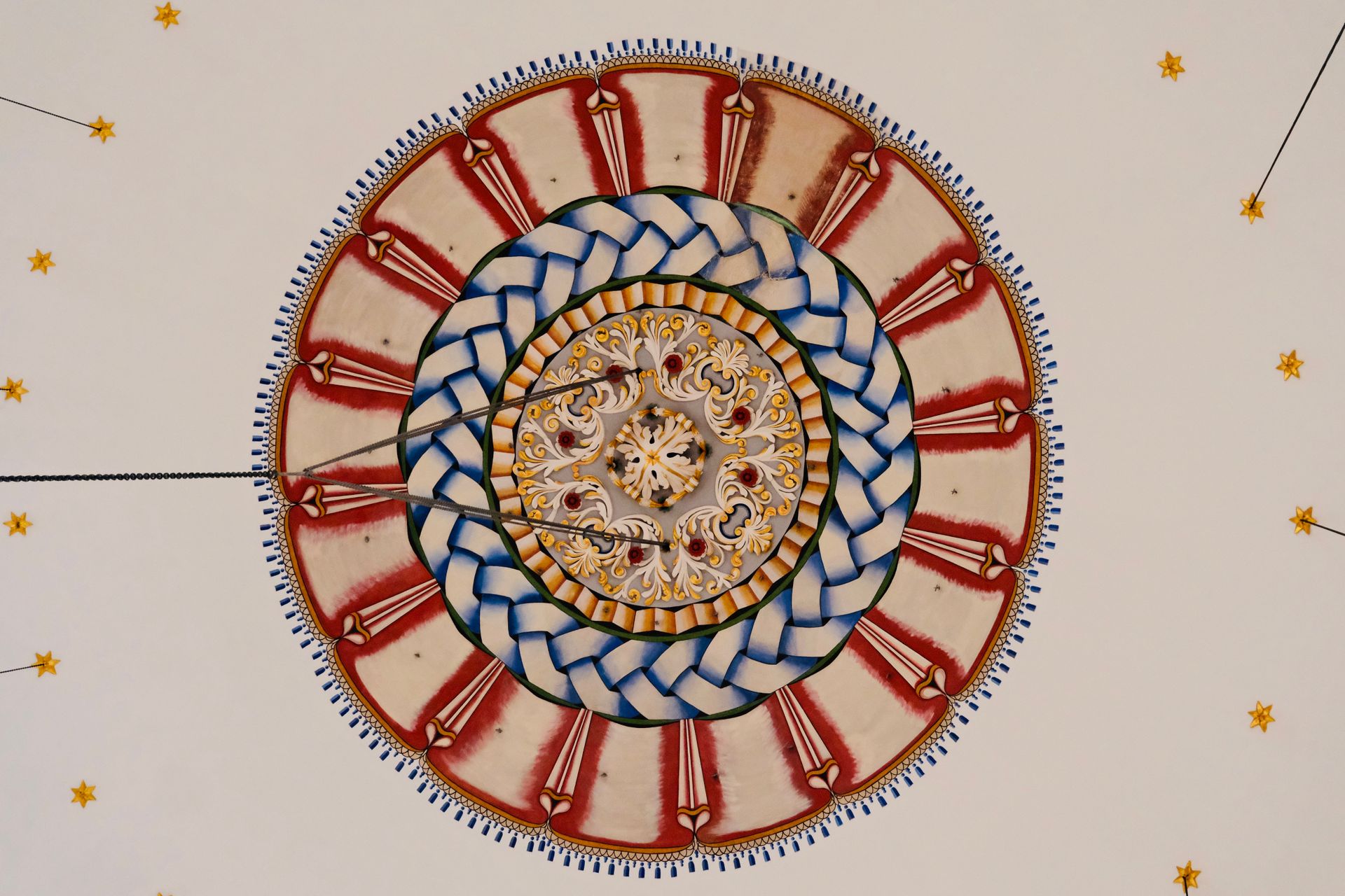 A stunning intricately detailed ceiling design featuring symmetrical patterns and rich colors.
