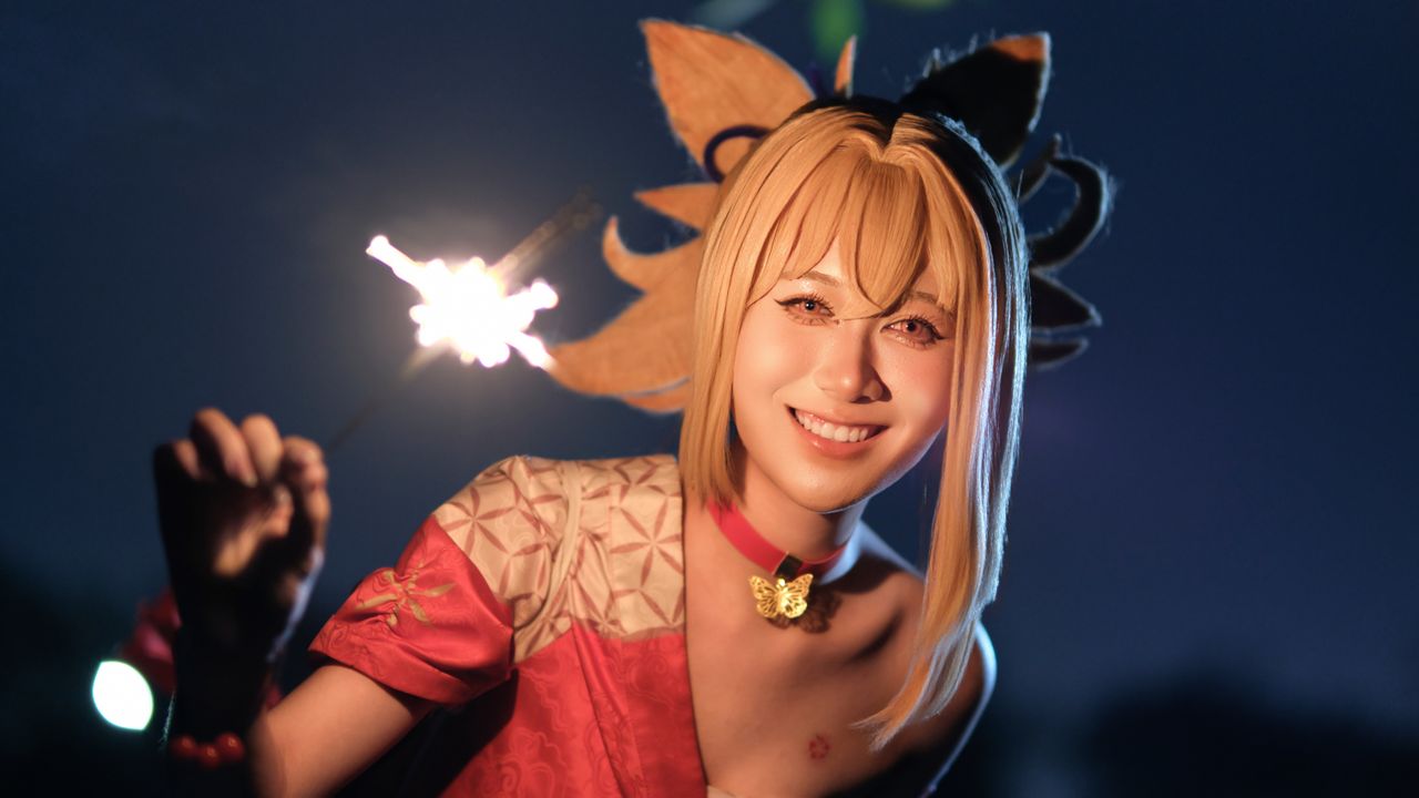smiling person in colorful cosplay with a sparkler creating a warm nig