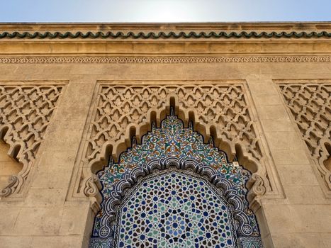 Intricate Moroccan tilework and stone carving in a traditional architectural design.