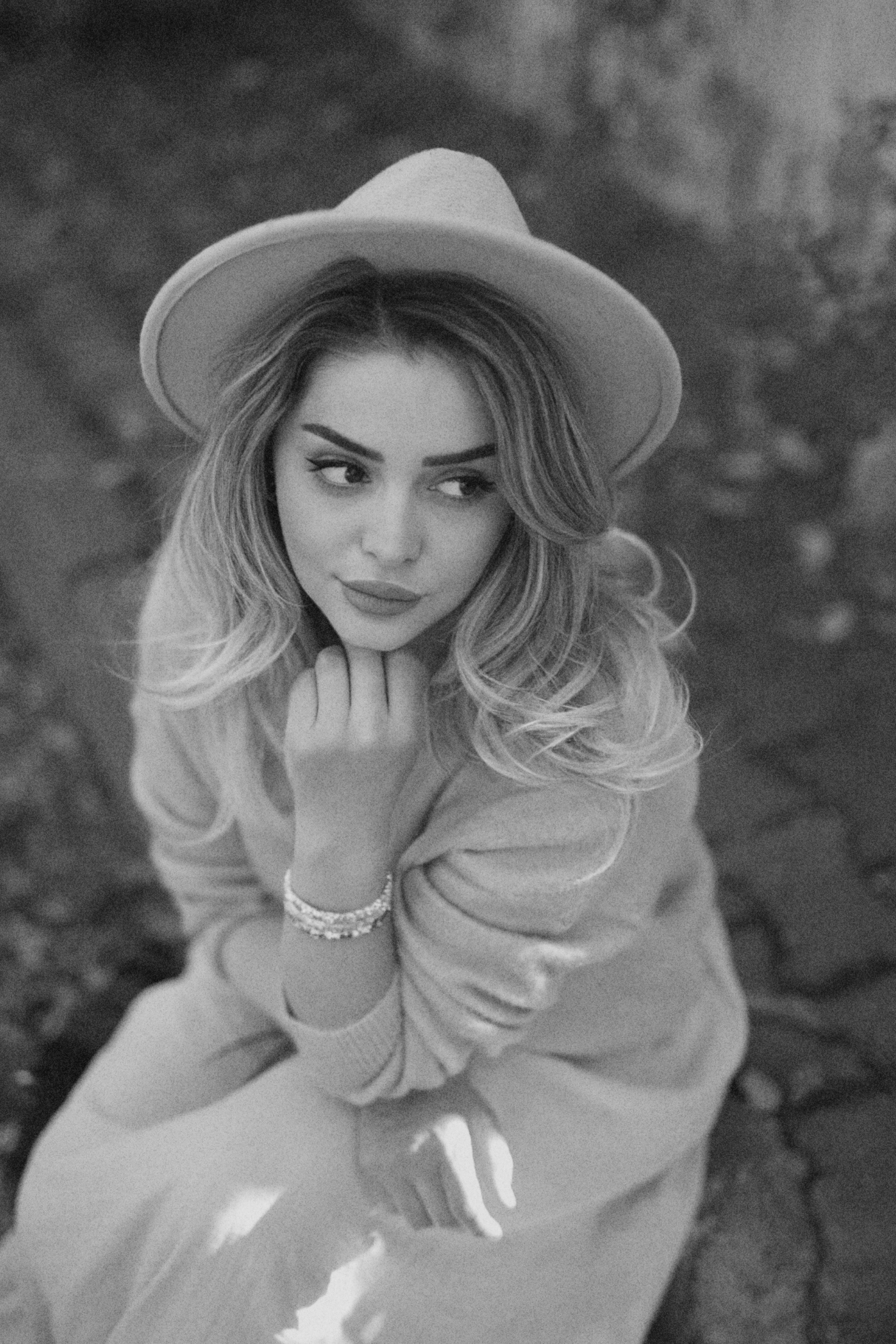 Black and white portrait of a stylish woman in a hat outdoors.
