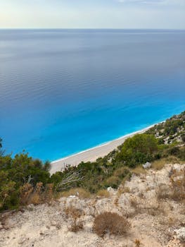 Breathtaking aerial view of Egremni Beach in Greece with vibrant blue waters and lush greenery.