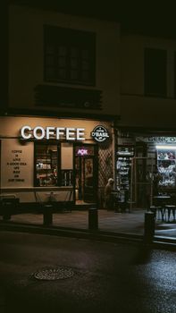 Exterior of a coffee shop in Konya at night, lit with a warm glow and urban ambiance.