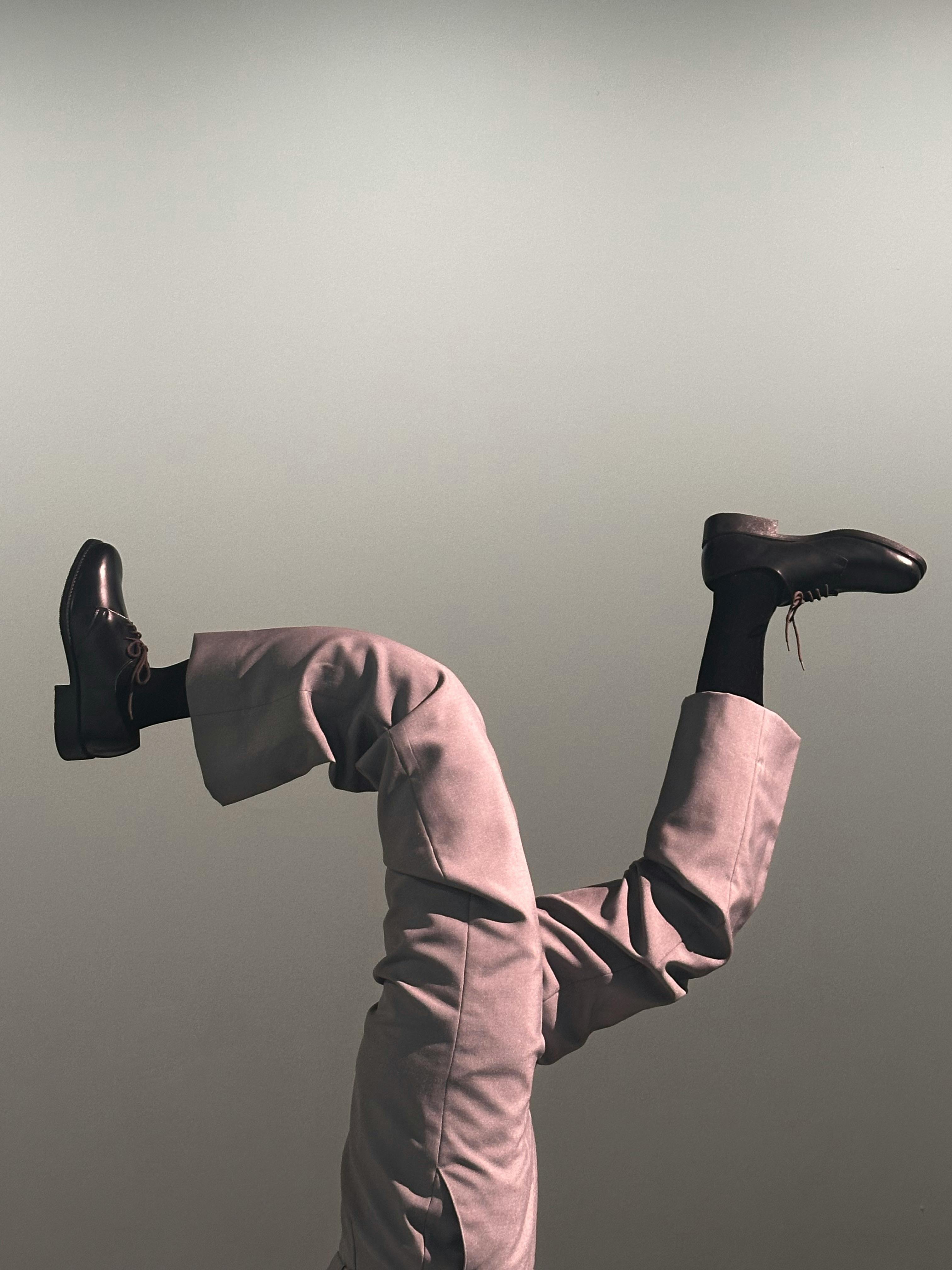 grátis Calças e sapatos elegantes dispostos de cabeça para baixo contra um fundo gradiente neutro. Estiloso e artístico. Foto profissional