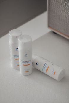 A minimalist image of three skincare product bottles on a white surface, emphasizing cleanliness and simplicity.. pexels, min