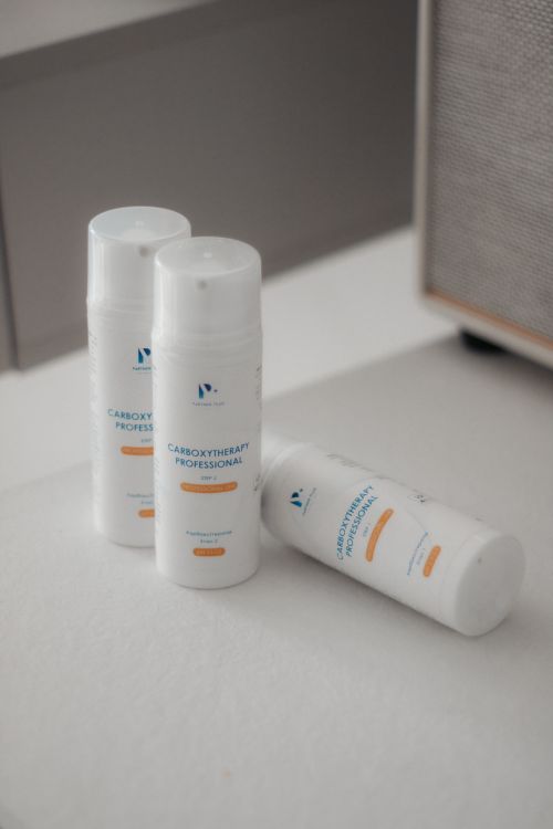 Free Minimalist display of three skincare bottles indoors, soft lighting. Stock Photo