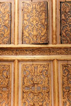 Detailed close-up of ornate Baroque wooden paneling with intricate gold patterns.