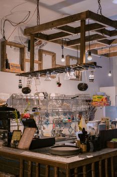 Rustic cafe interior with hanging lights and exposed shelving, creating a cozy atmosphere.